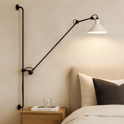 Wall-mounted lamp with a long arm in a bedroom setting.