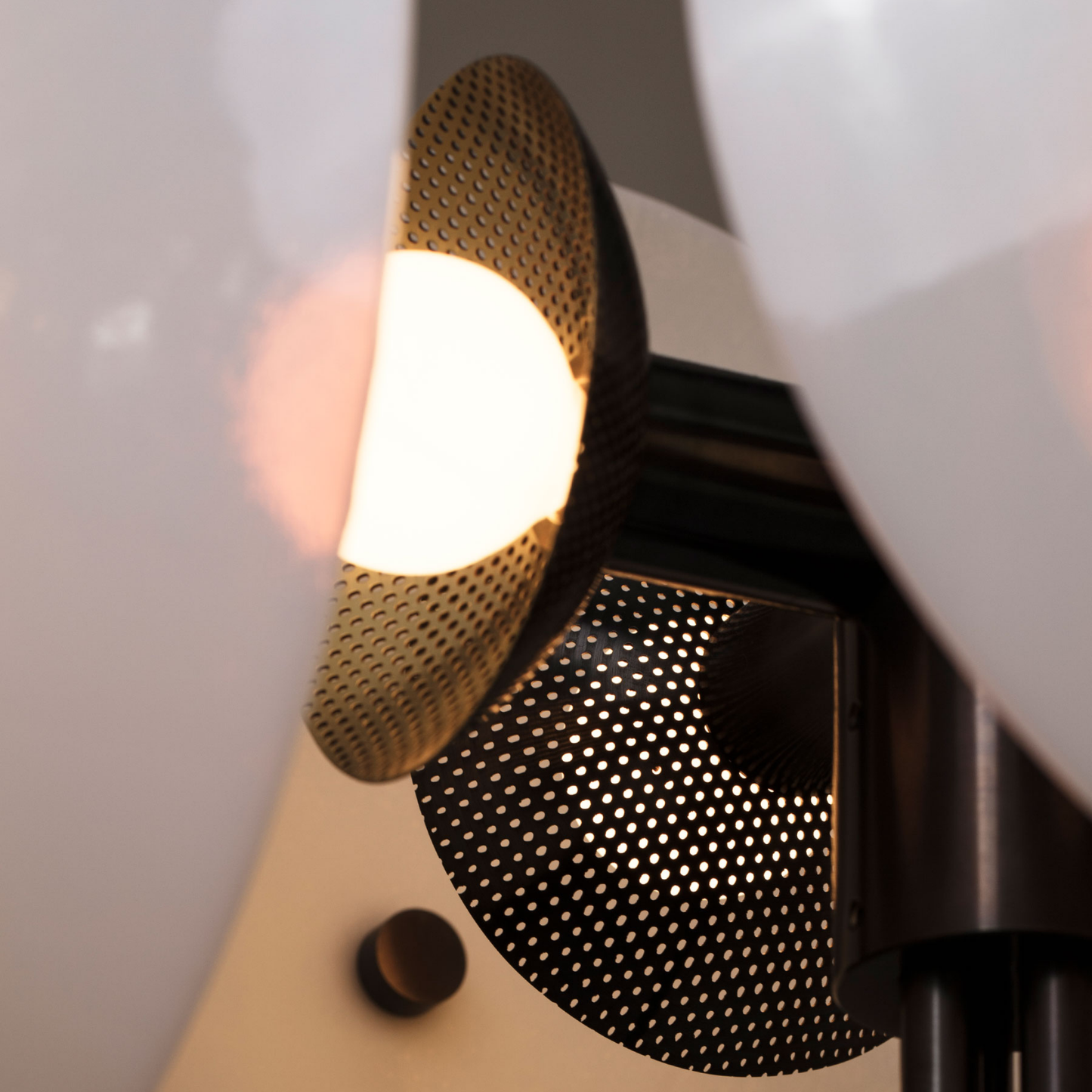 Close-up of a light fixture with a perforated design on a blurred background