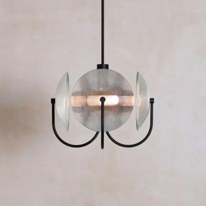 Modern pendant light with glass shade and black metal fixture on a neutral background