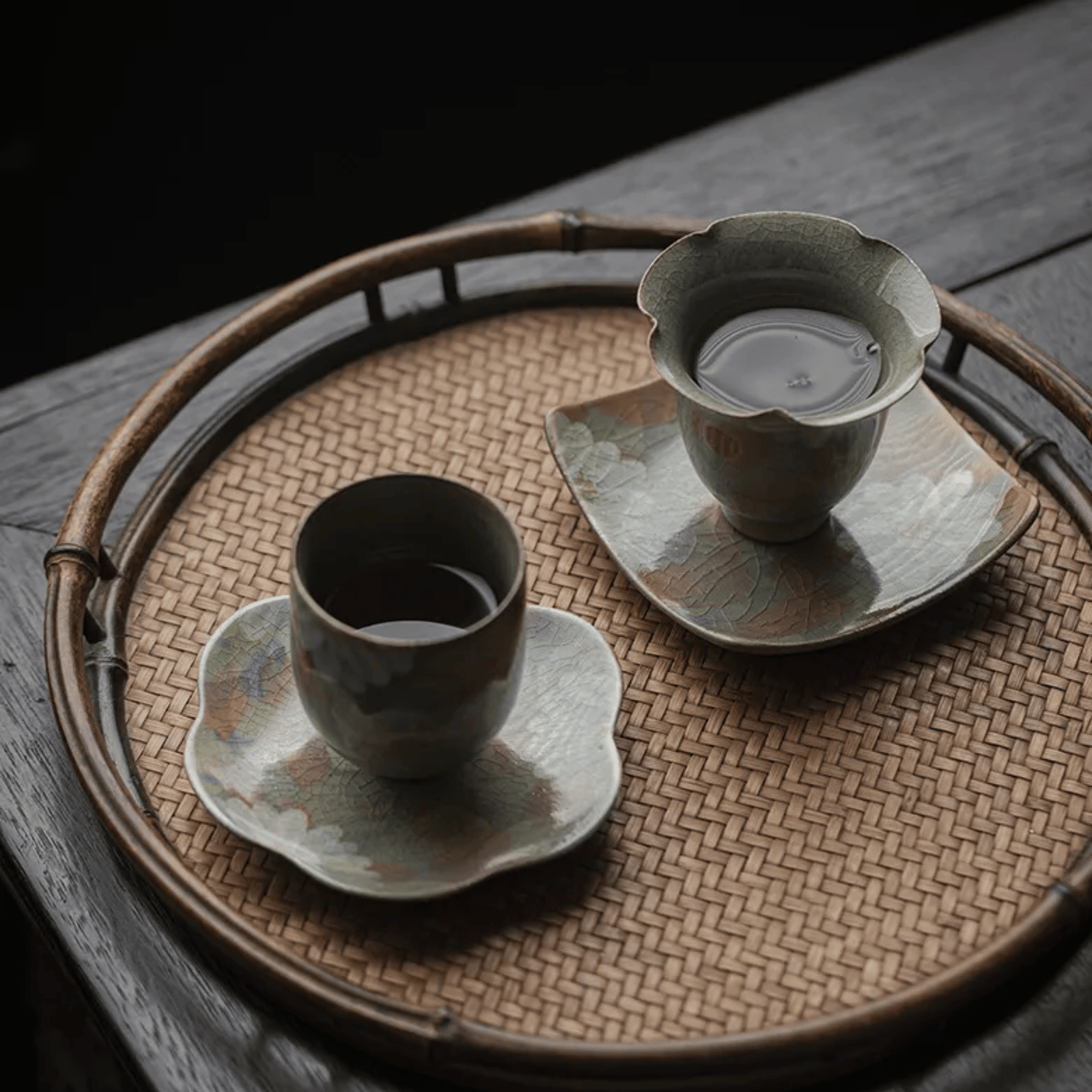 Tea set with cup, saucer, and teapot on a woven tray.