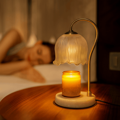 Table lamp with a candle on a wooden surface, with a blurred background of a person lying down.