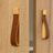 Gold and brown leather strap hanging on a wooden surface
