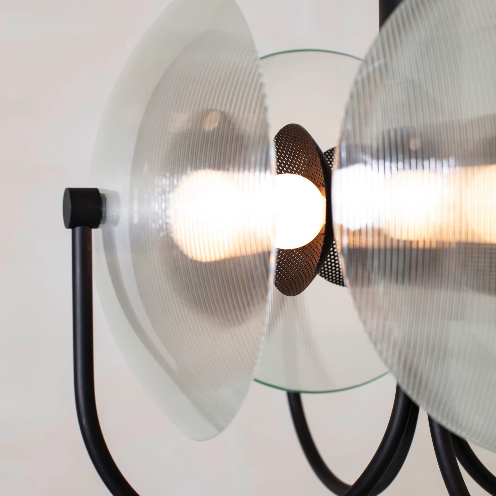 Modern wall light fixture with glass shades and black metal accents on a white background