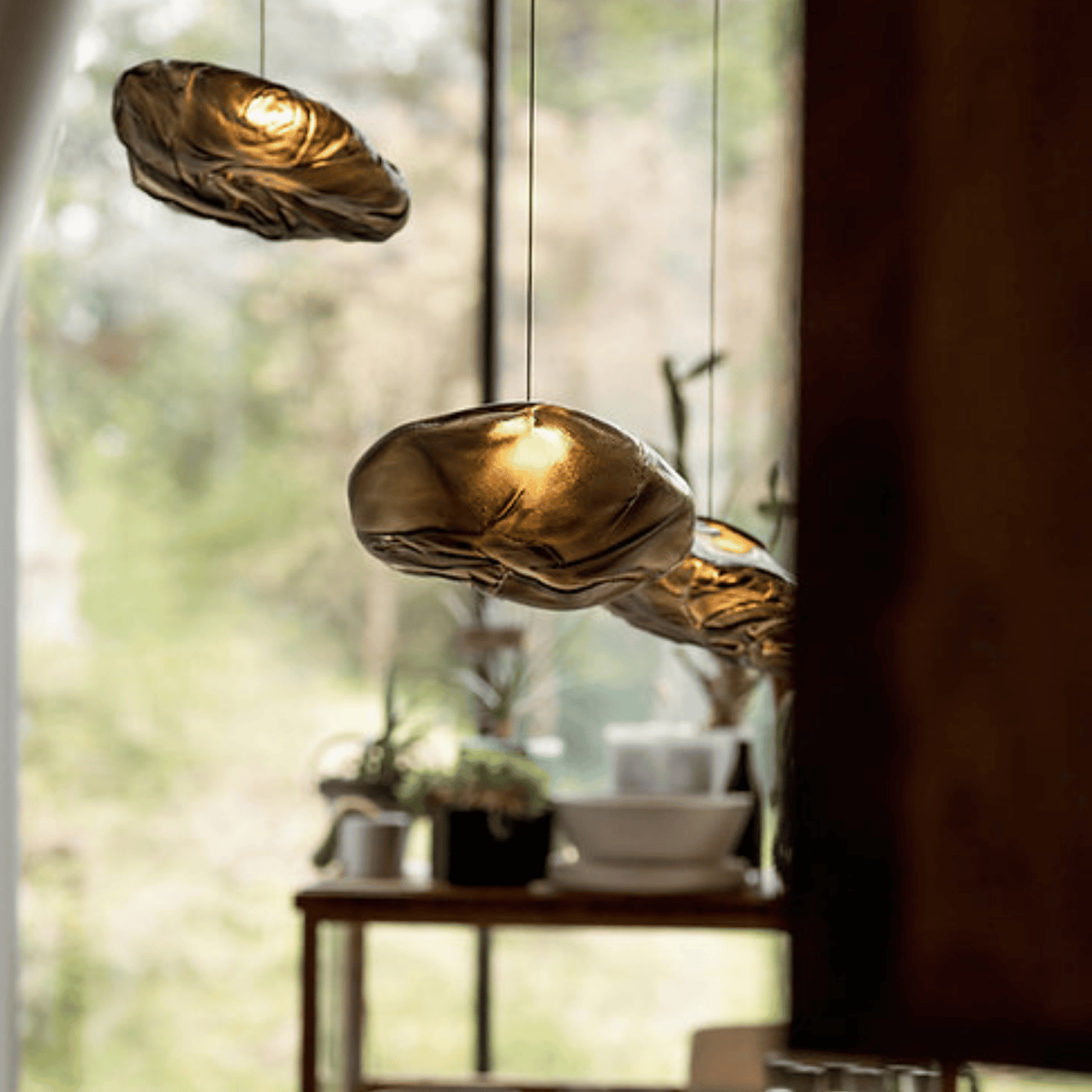 Gold pendant lights hanging in a room with a blurred background