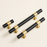 Set of black and gold cabinet handles on a light beige background