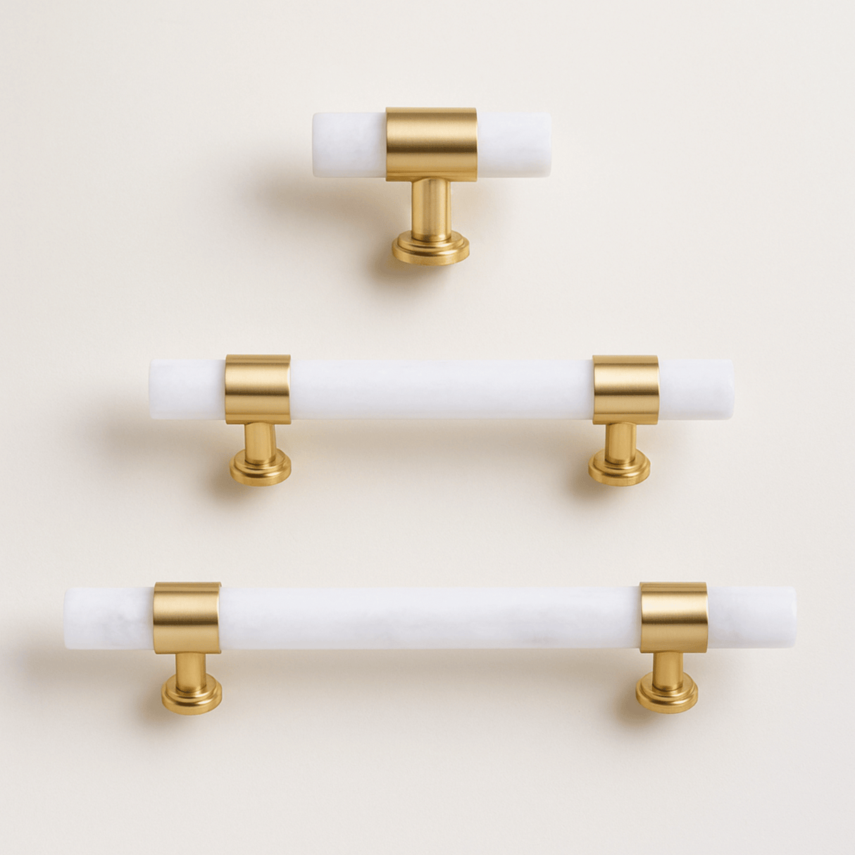 Set of gold and white cabinet handles on a beige background