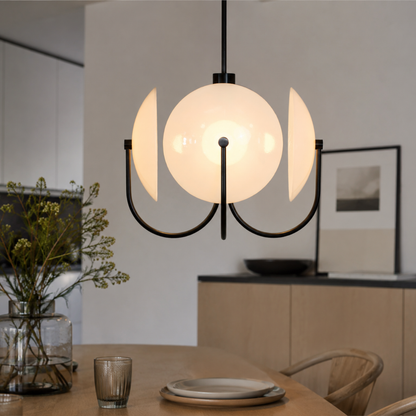 Modern pendant light hanging above a dining table with a neutral background