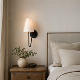 Nursery room with wooden nightstand, lamp, and decorative items.