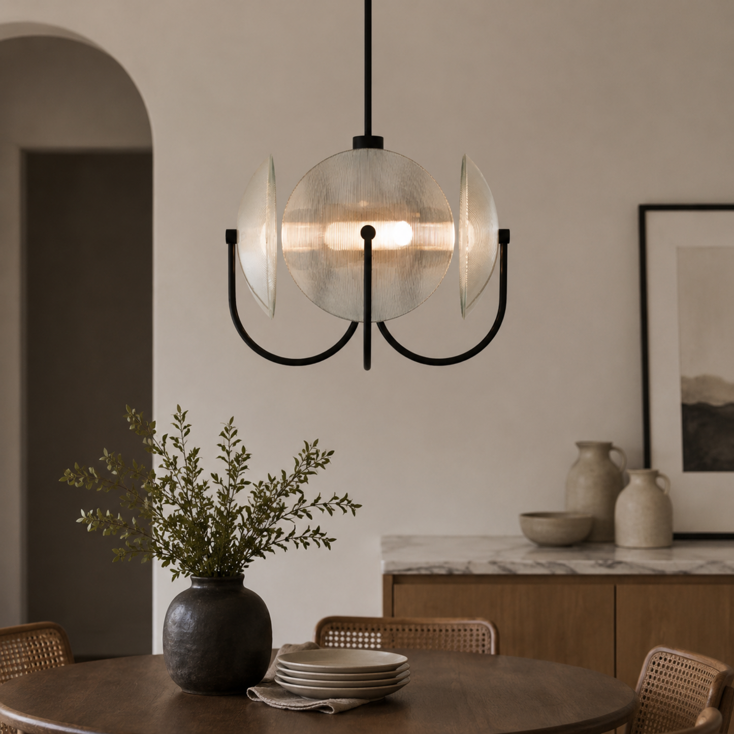 Modern pendant light fixture in a dining room setting with a neutral color palette.
