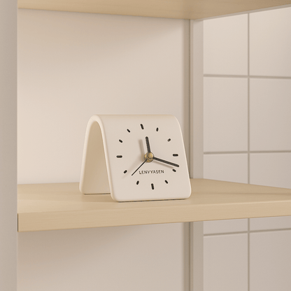 White clock with black hands and 'LENYVAEN' branding on a light wooden shelf.