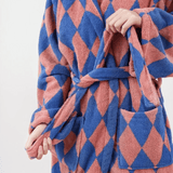 Blue and pink diamond patterned robe held by a person against a white background