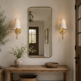 Niche with a wooden table, mirror, and decorative items against a neutral wall.