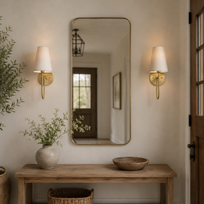 Niche with a wooden table, mirror, and decorative items against a neutral wall.