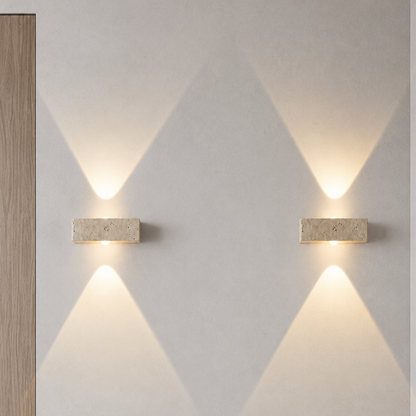 Two wall-mounted lights on a light gray wall with geometric patterns.