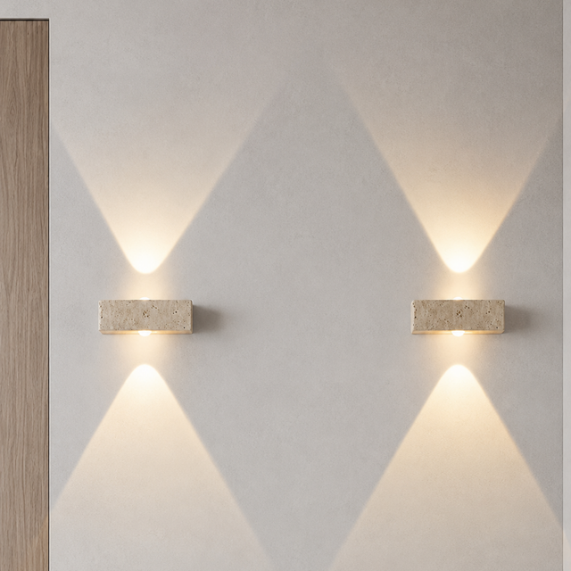 Two wall-mounted lights on a light gray wall with geometric patterns.