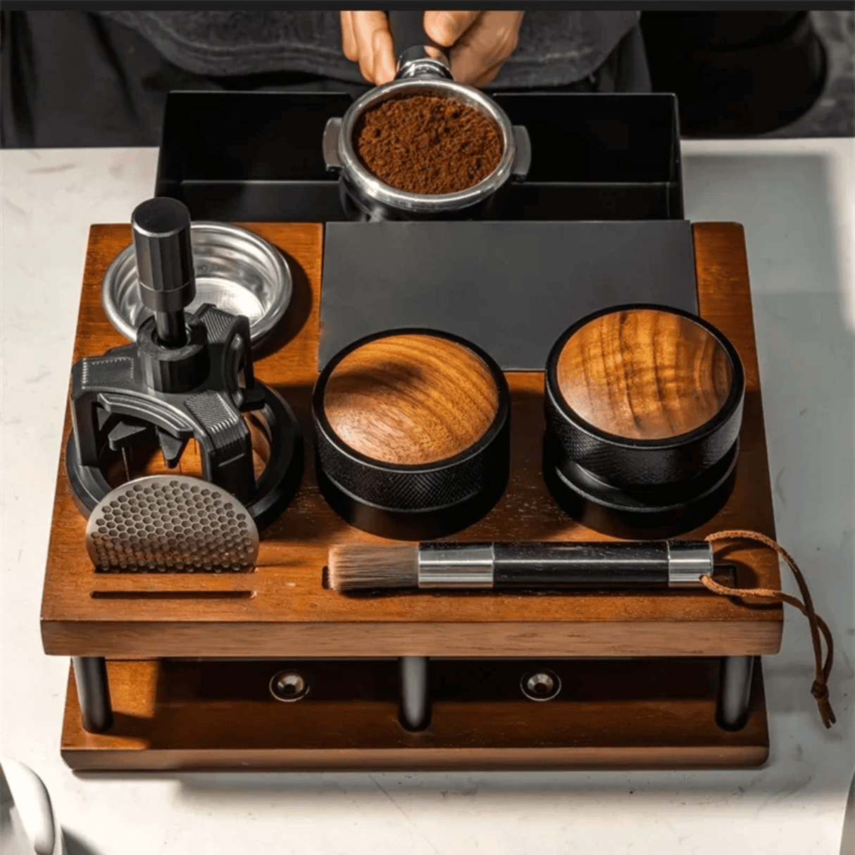 Wooden coffee grinder set with various components on a white surface