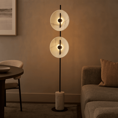 Modern floor lamp with two circular lights in a living room setting.