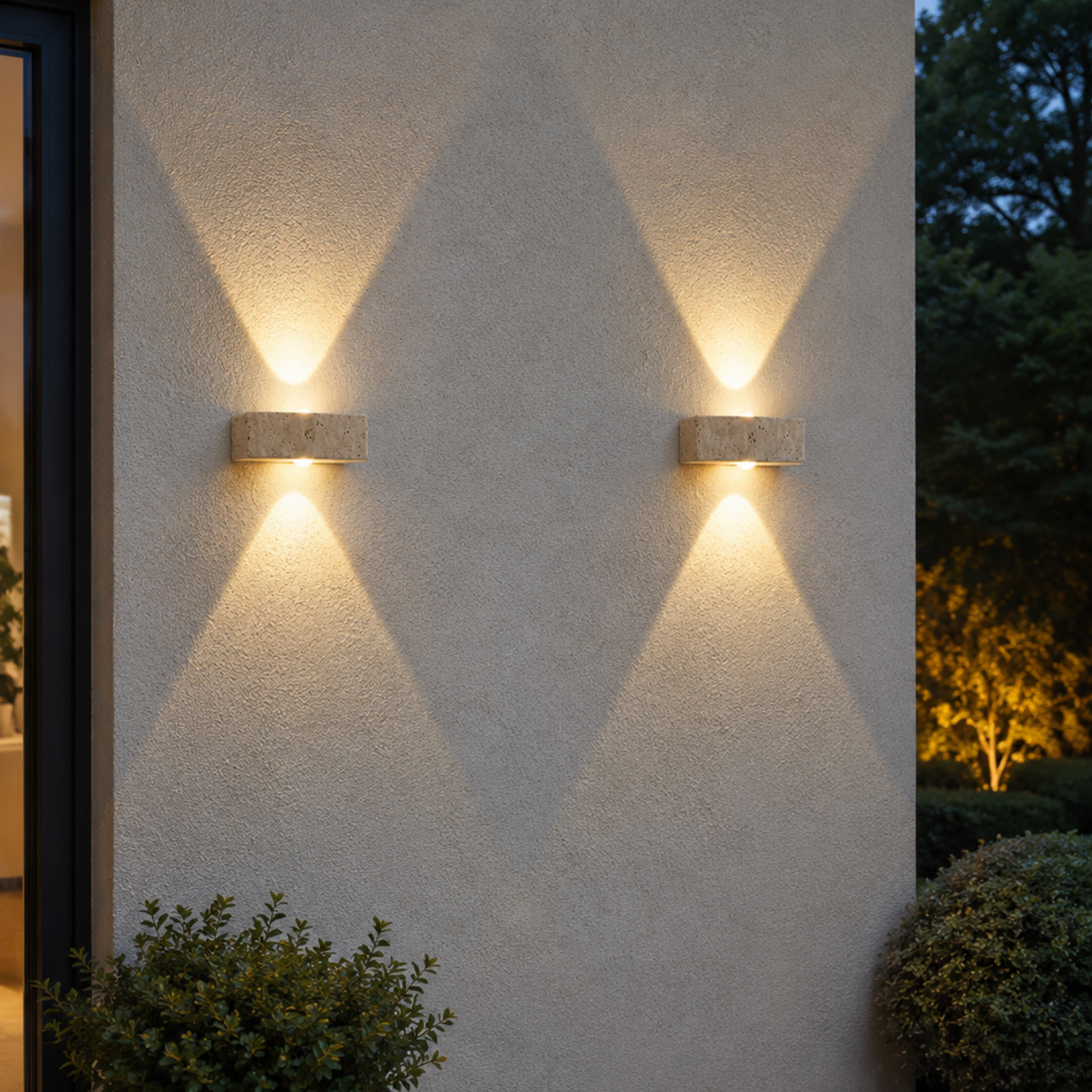 Two outdoor wall lights on a textured wall with garden and tree in the background