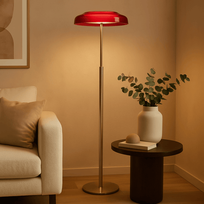 Living room with a red floor lamp, beige sofa, and small table with a plant.