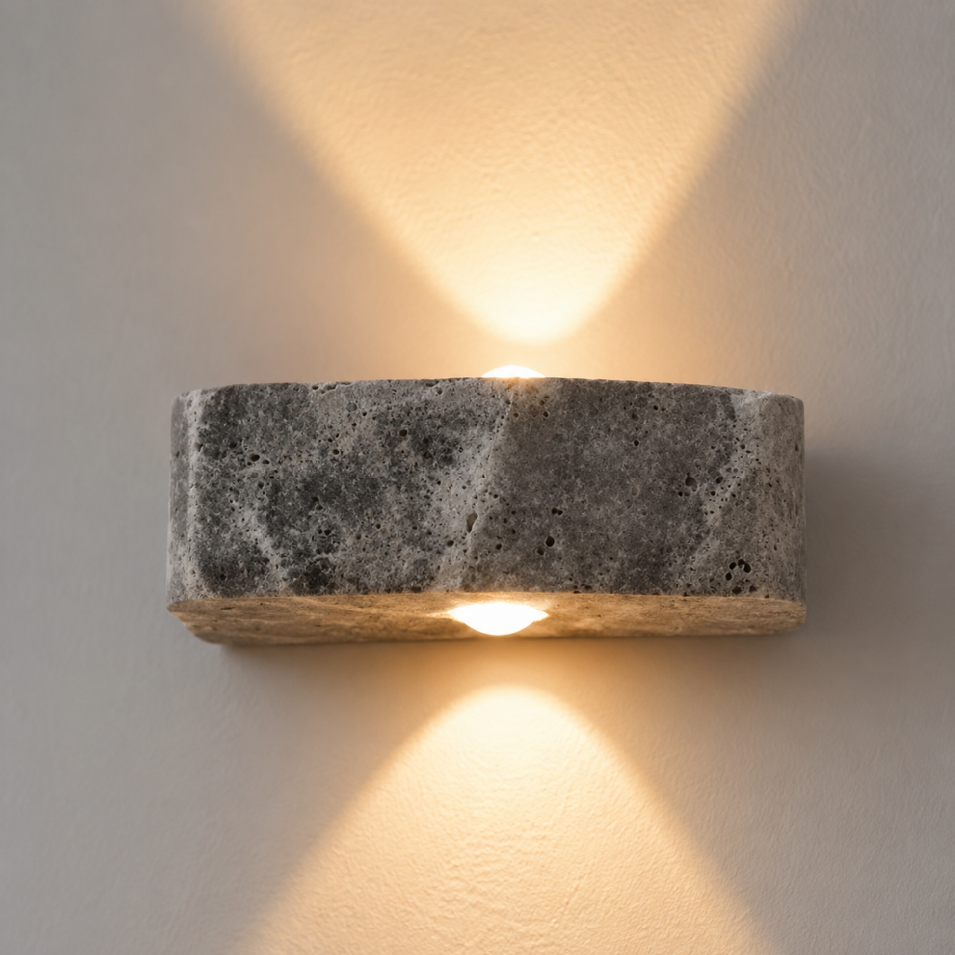 Concrete wall sconce with a warm glow on a neutral background
