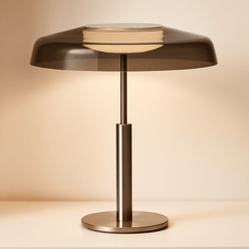 Modern table lamp with a metallic base and smoked glass shade on a beige background