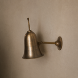Bronze wall-mounted lamp on a beige wall