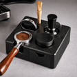 Coffee grinder and accessories on a black stand with a wooden handle.