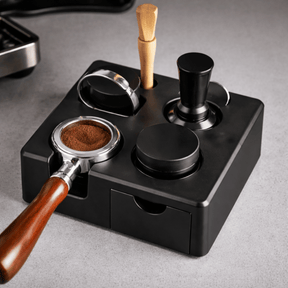 Coffee grinder and accessories on a black stand with a wooden handle.