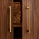 Wooden cabinet with gold handles and woven basket inside