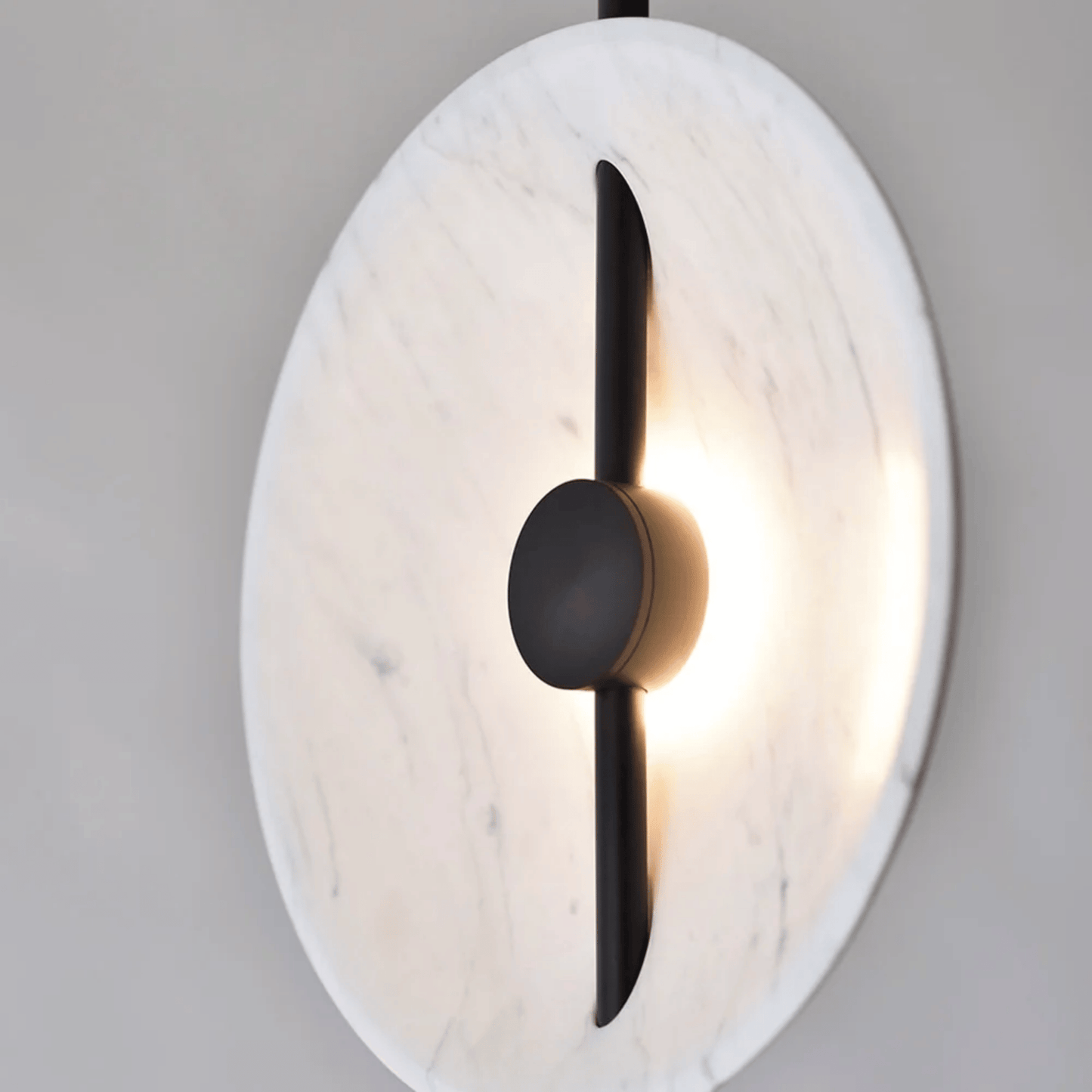 Modern wall sconce with marble-like finish and black accent on a gray background
