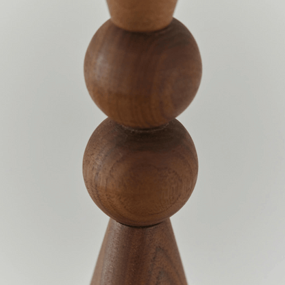 Close-up of a wooden candle holder with spherical design on a light gray background
