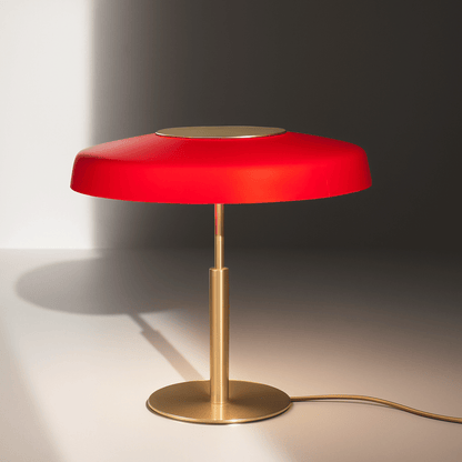 Red table lamp with gold base on a neutral background
