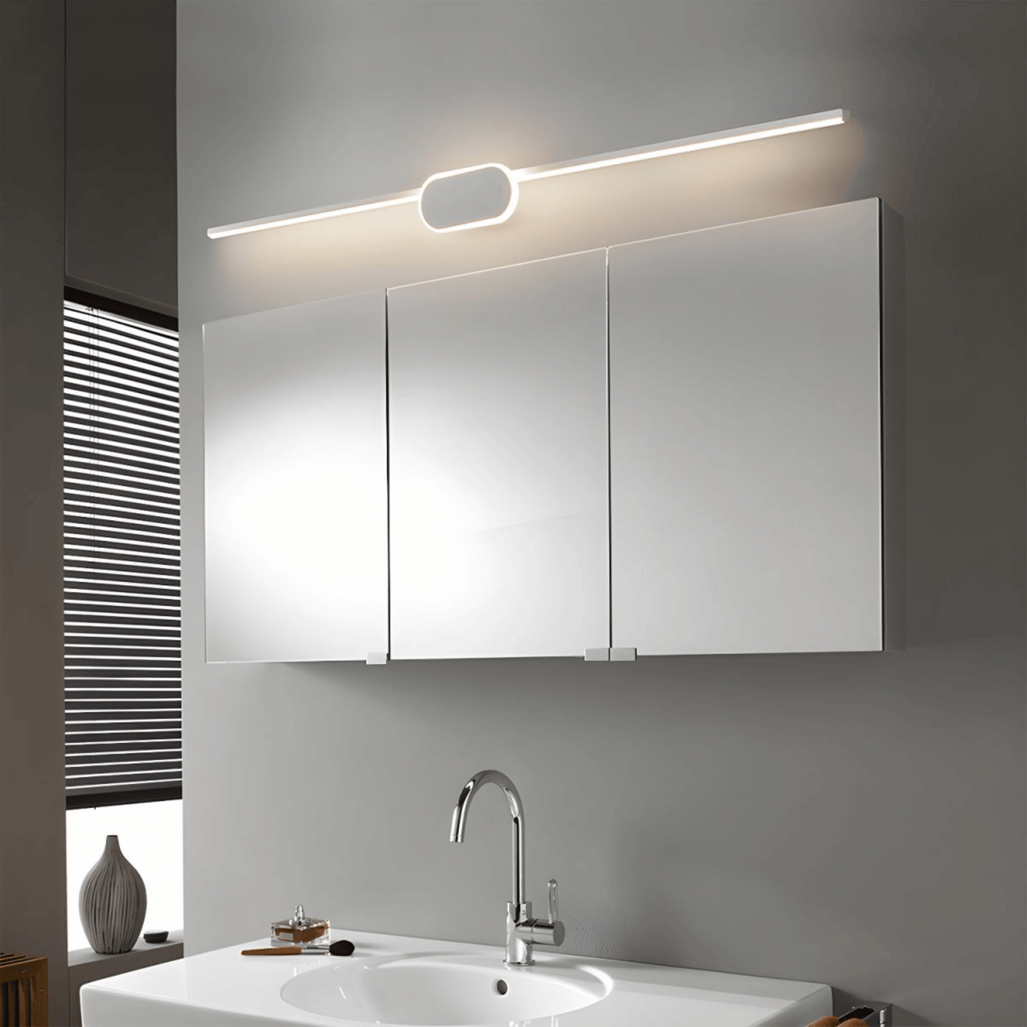Bathroom with a three-door cabinet above a sink, illuminated by a light fixture.