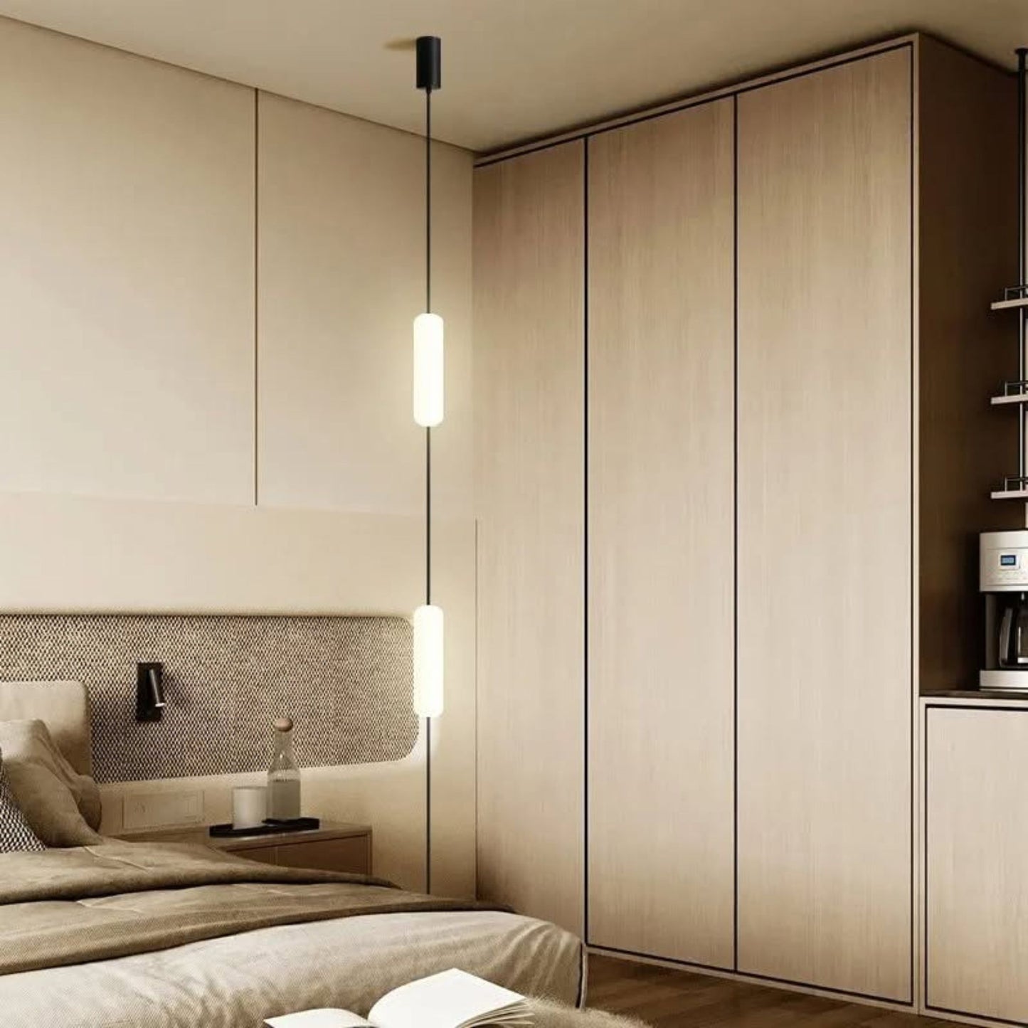 A modern vertical tube pendant light hanging beside a bed in a minimalist bedroom with light wood paneling.