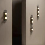 close up of single dome bulb in brushed brass ring on textured metal plate