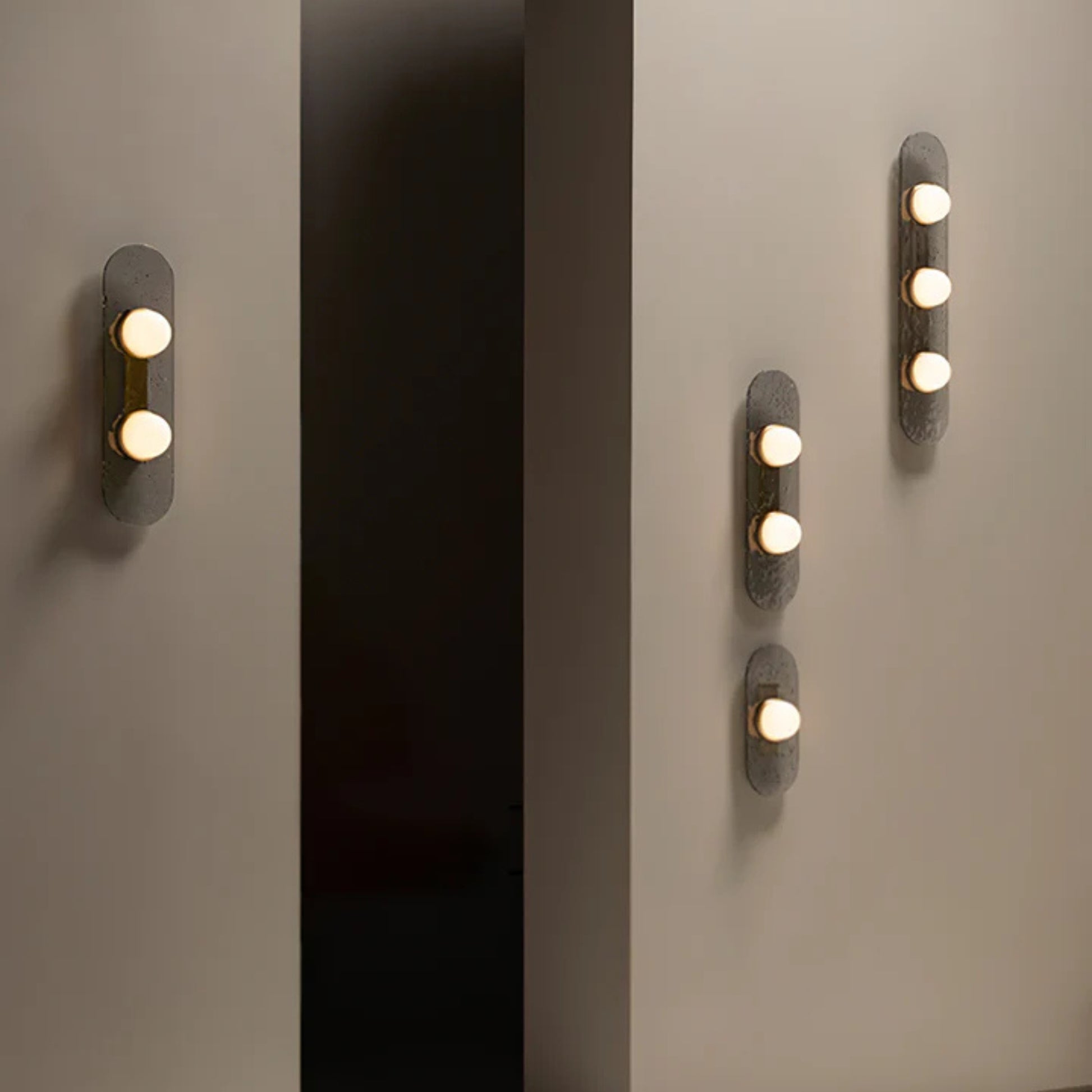 close up of single dome bulb in brushed brass ring on textured metal plate