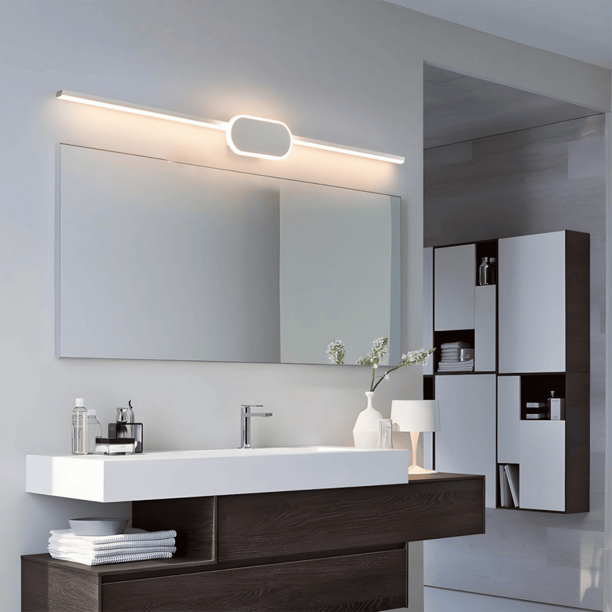 Modern bathroom vanity with mirror, lighting fixture, and decorative elements.