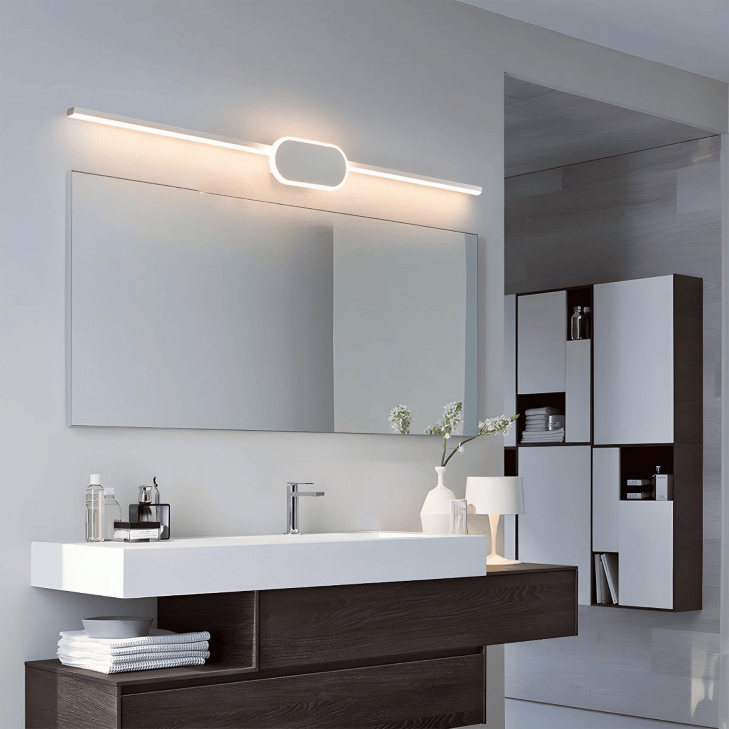 Modern bathroom vanity with mirror, lighting fixture, and decorative elements.
