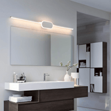 Modern bathroom vanity with mirror, lighting fixture, and decorative elements.