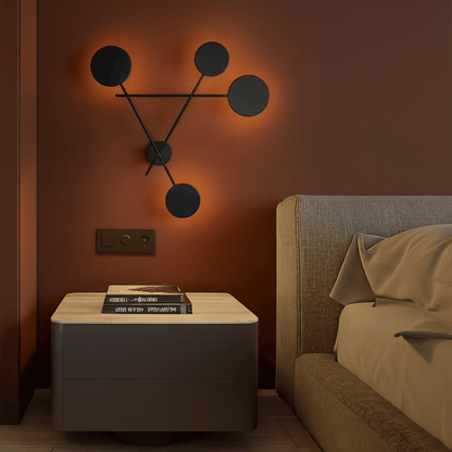 Modern bedroom with a side table, wall sconce, and bed.