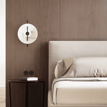 Modern bedroom with a bed, side table, and wall lamp.
