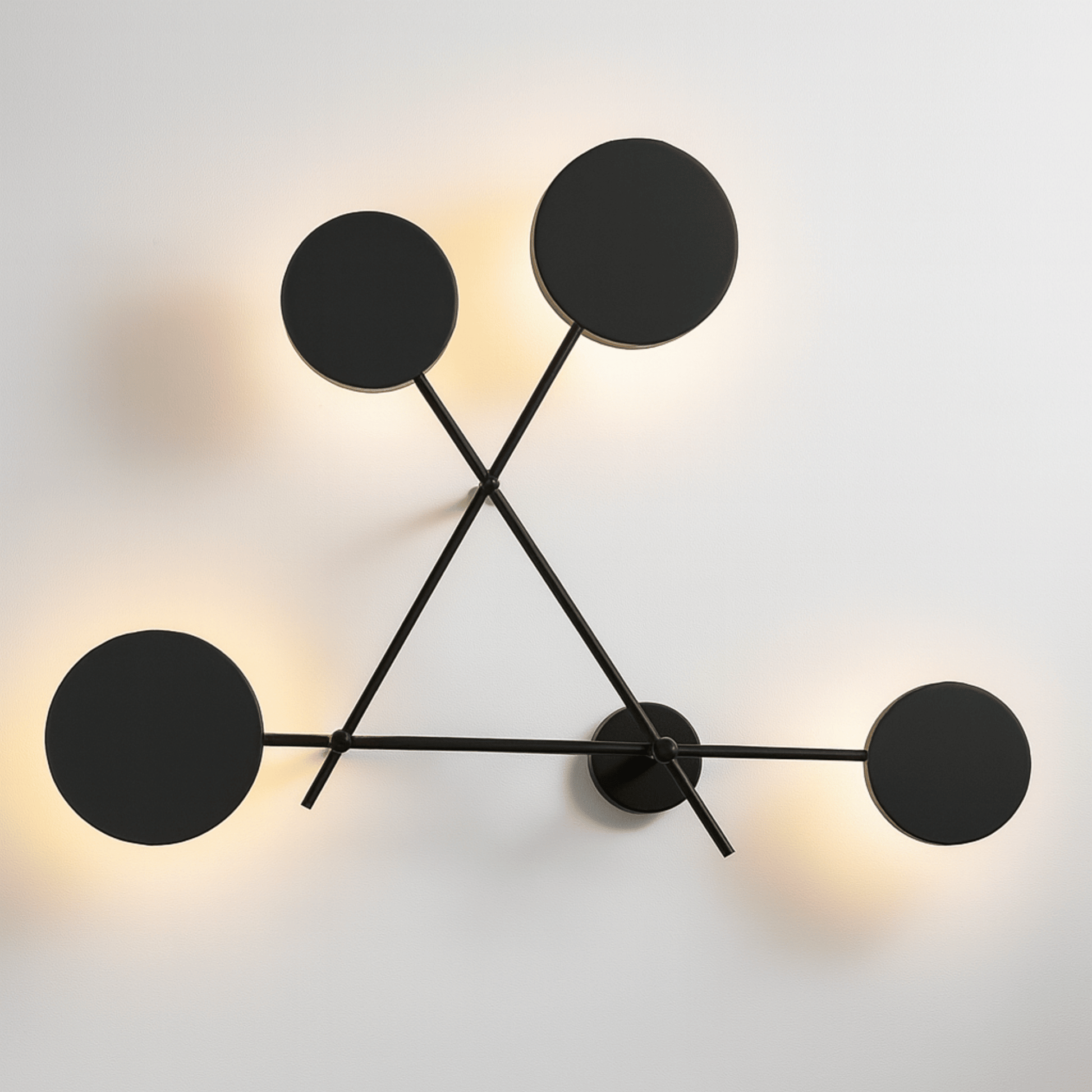 Modern wall light fixture with four black circular lights on a white background