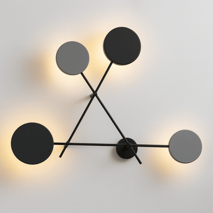 Modern wall light fixture with black circular shades on a white background