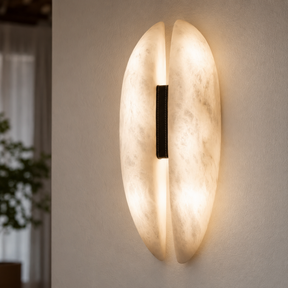 Modern wall sconce with a warm glow on a neutral wall.