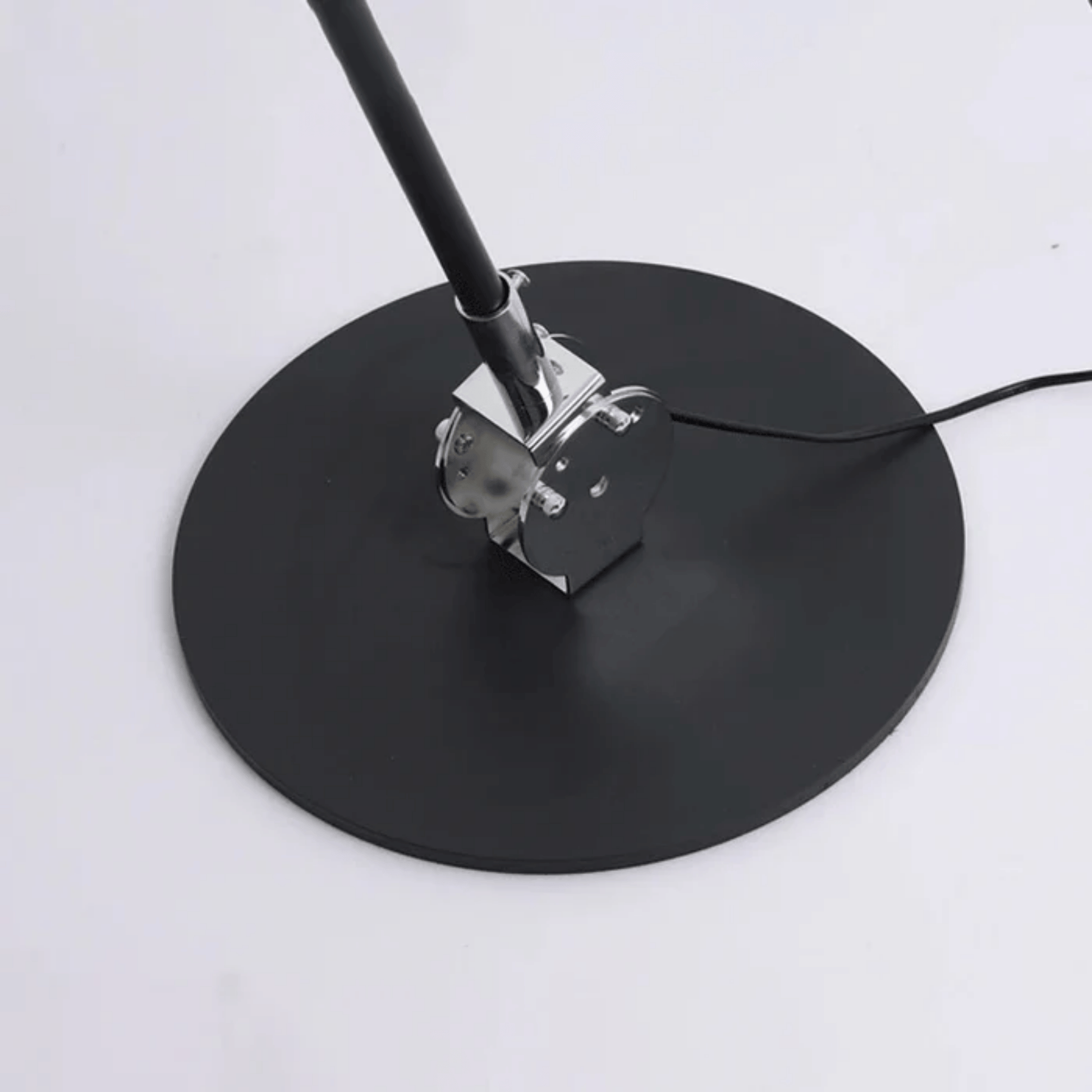 Black round stand with a metal clamp on a white background