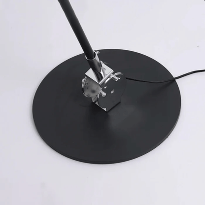 Black round stand with a metal clamp on a white background