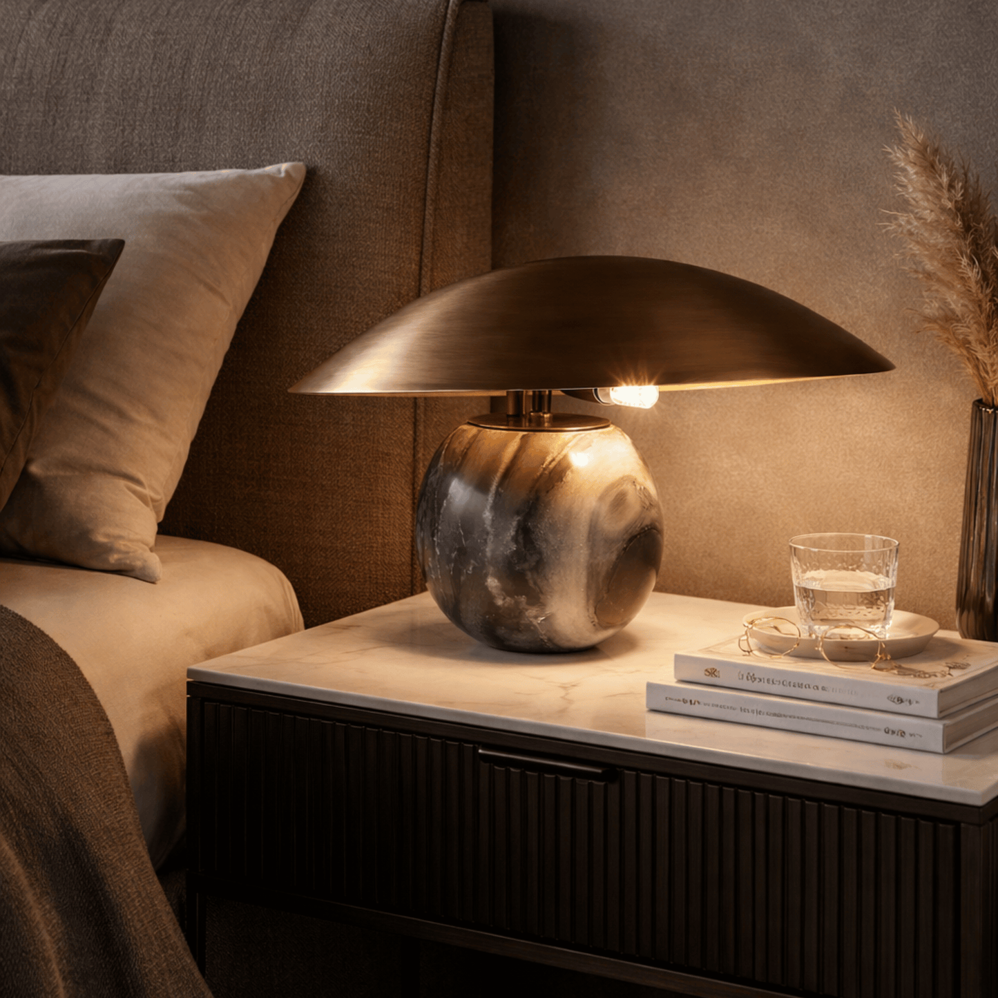 Decorative lamp on a nightstand with books and a glass of water in a cozy room.