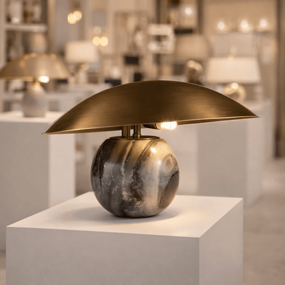 Decorative table lamp with marble base and gold shade in a showroom setting