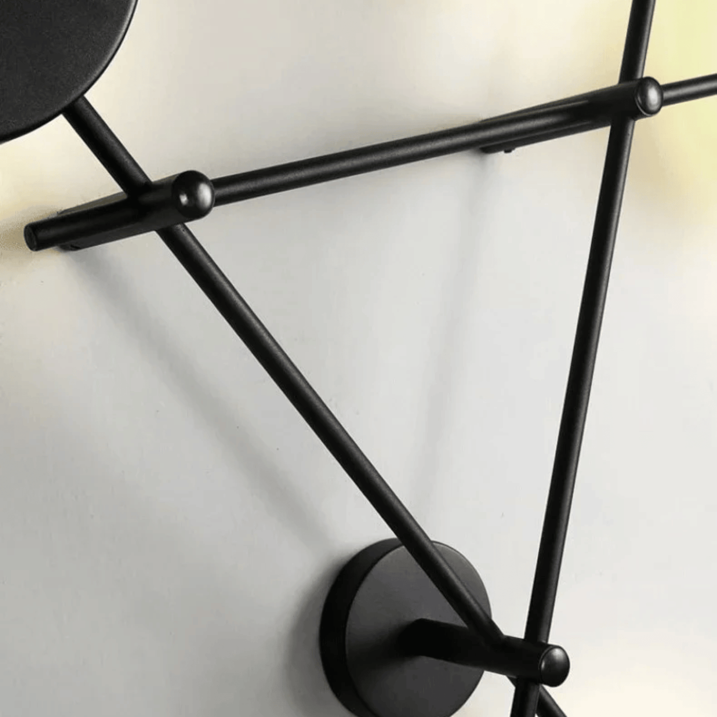 Black wall-mounted lamp with geometric design on a white background