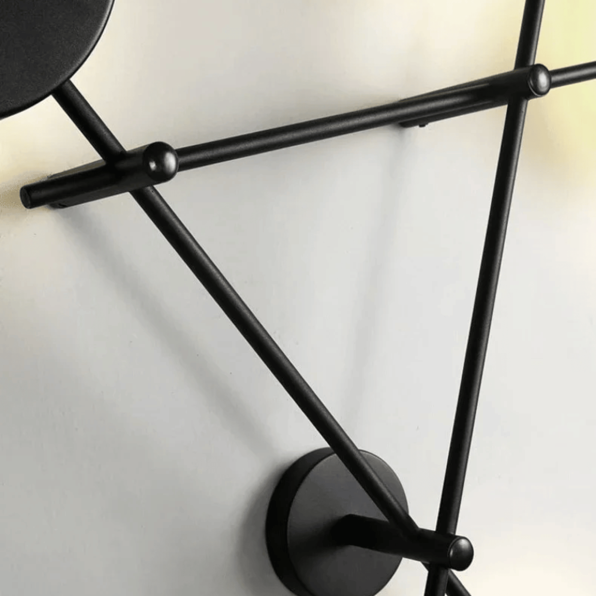 Black wall-mounted lamp with geometric design on a white background